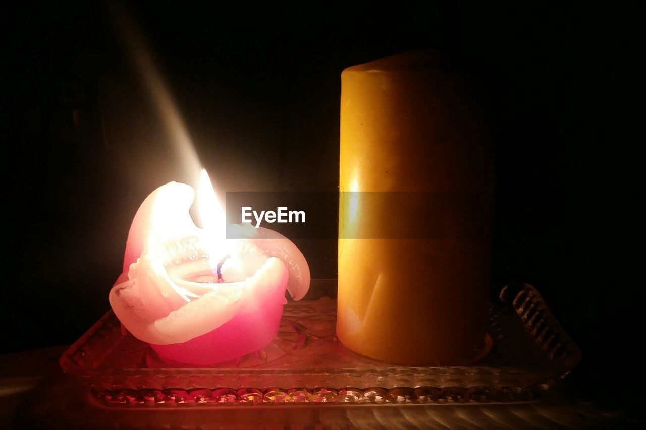 CLOSE-UP OF ILLUMINATED BURNING CANDLE