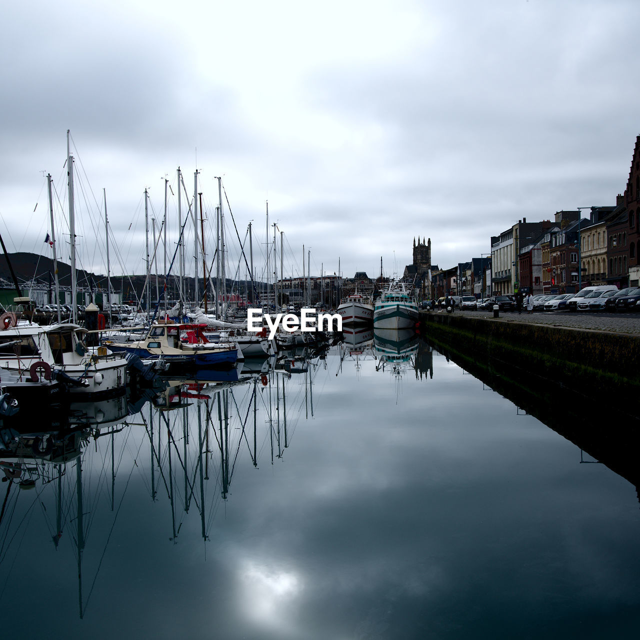 BOATS MOORED AT HARBOR AGAINST SKY