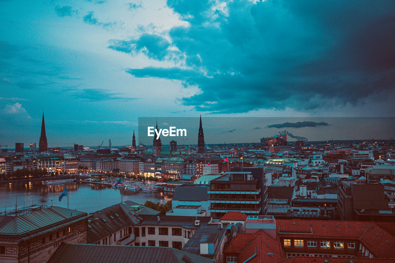 High angle view of buildings in city against cloudy sky during sunset