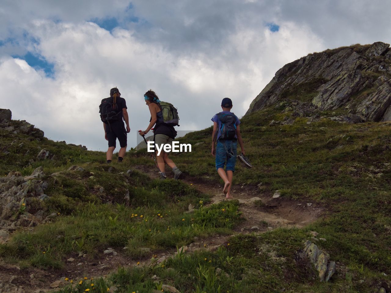 REAR VIEW OF PEOPLE WALKING ON MOUNTAIN