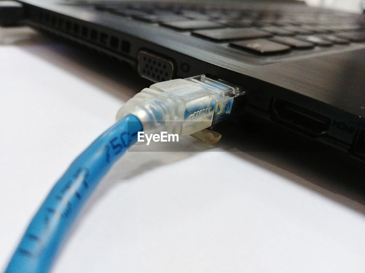 Close-up of usb cable connected to laptop on table