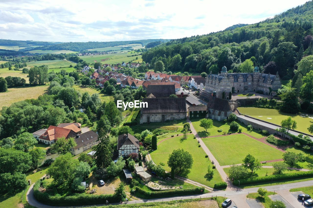 HIGH ANGLE VIEW OF TREES AND HOUSES AGAINST BUILDINGS