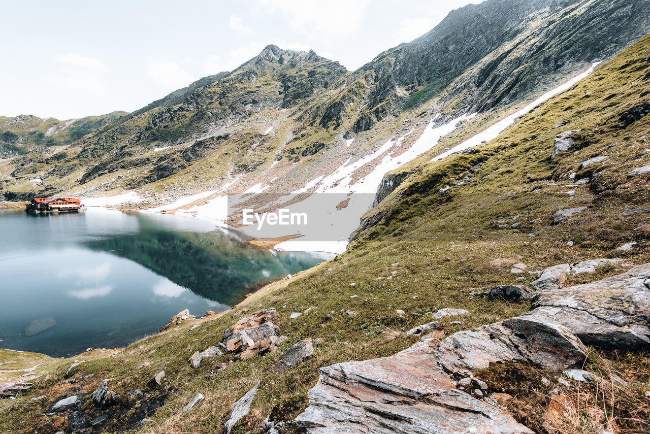 Lake on transfagarasan with snowy ridges and reflection