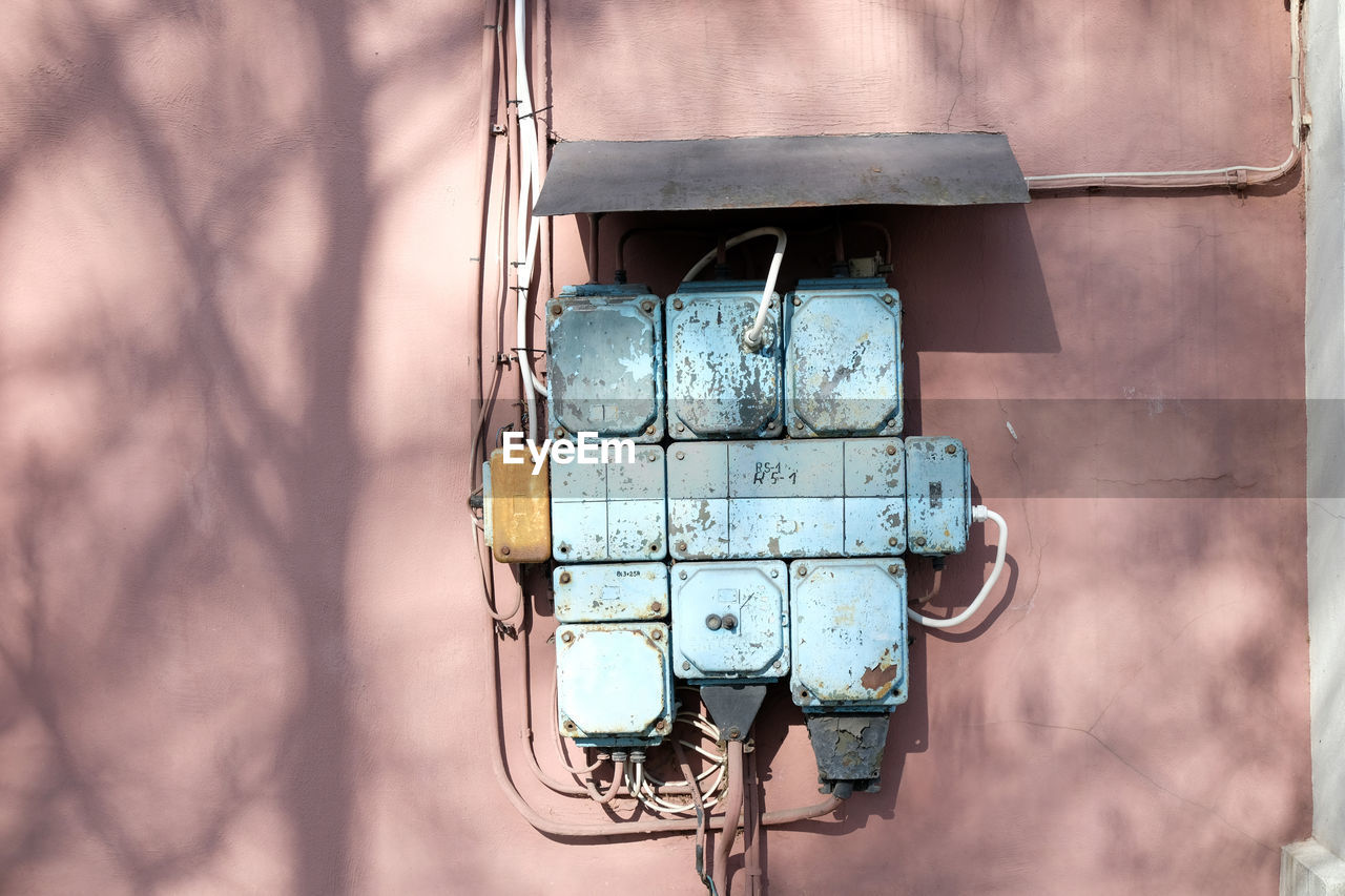 Vintage electricity circuit box, blue on a pink wall, old engineering technology. high voltage