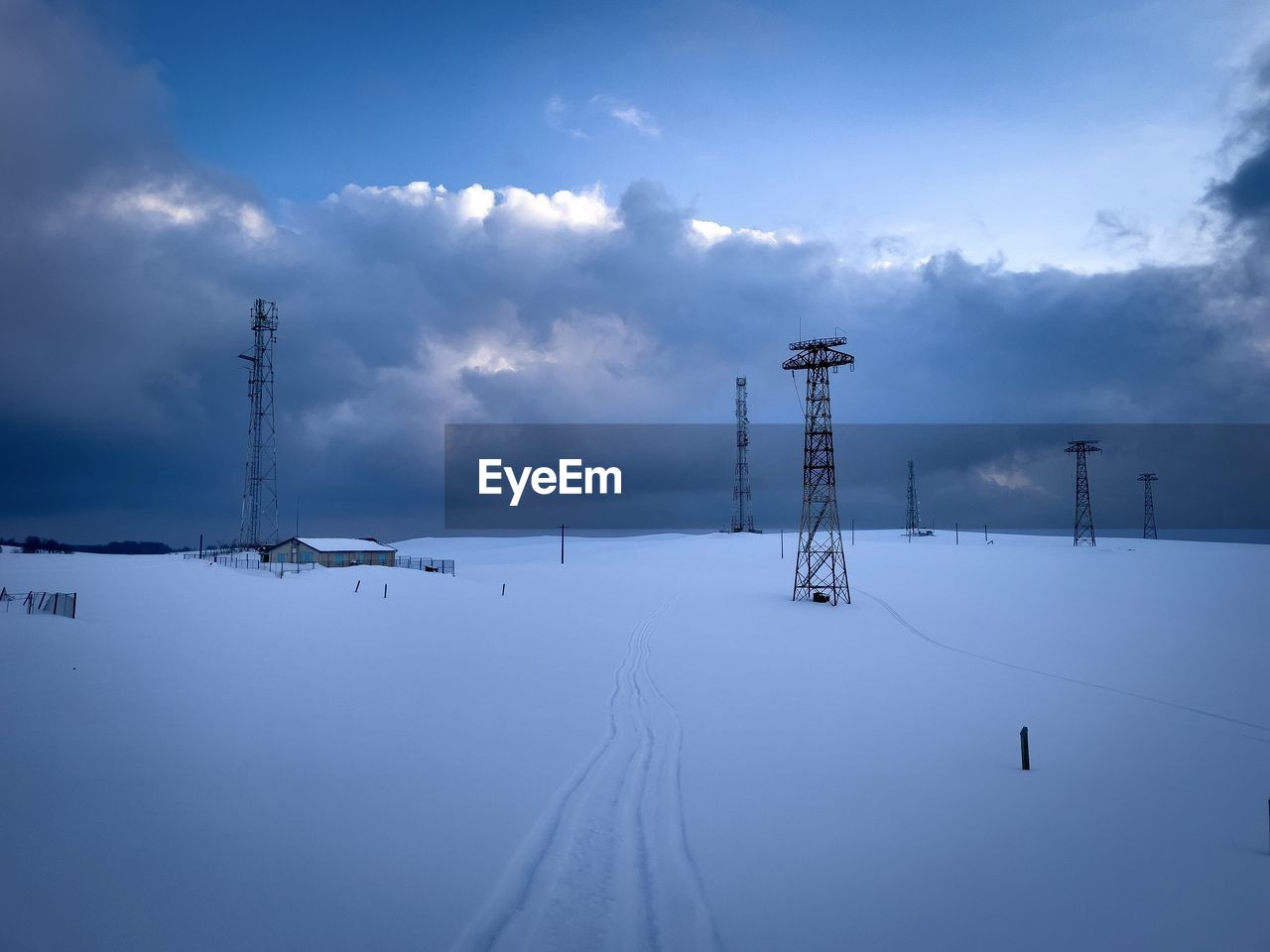 Transmission towers in the mountains during winter on a cloudy day