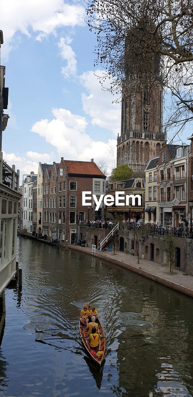 Canal amidst buildings in city against sky