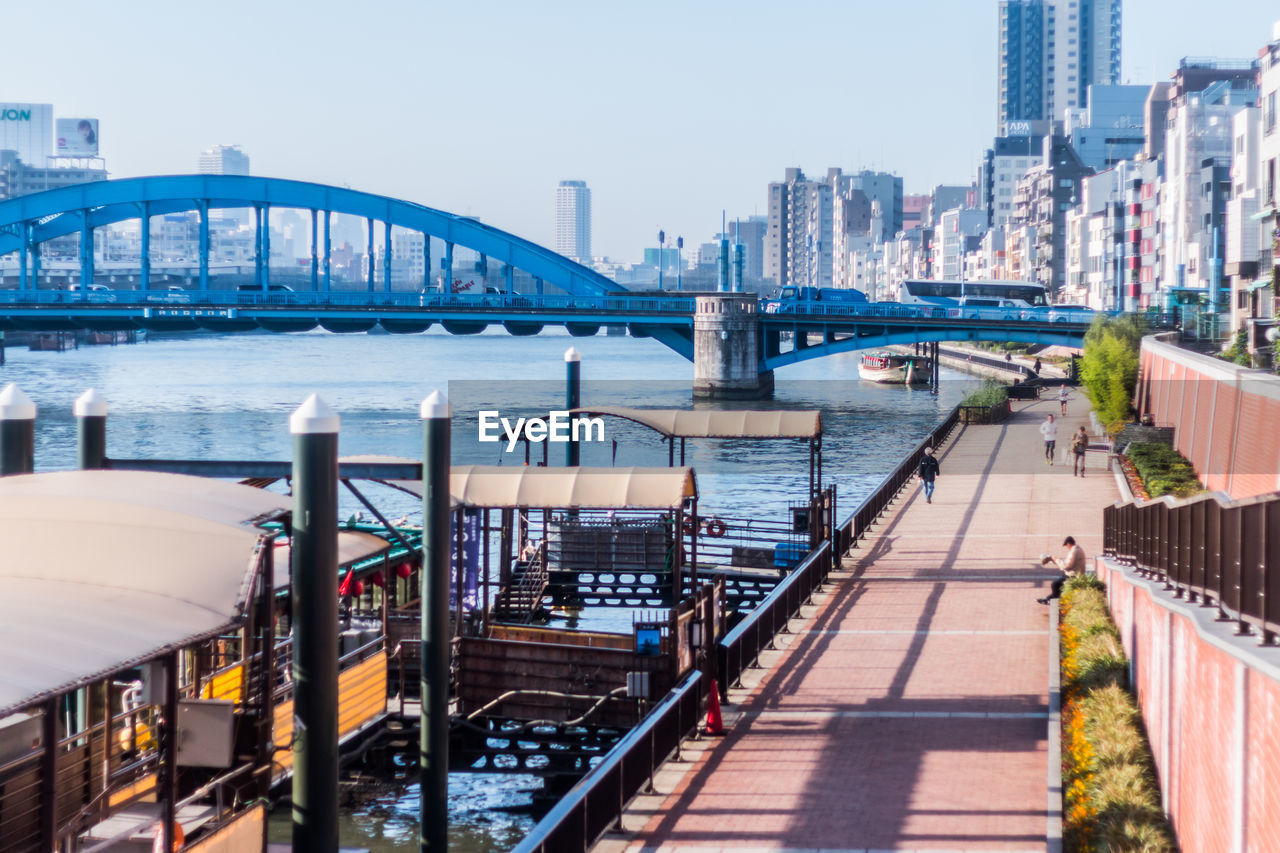 Bridge over river in city against clear sky