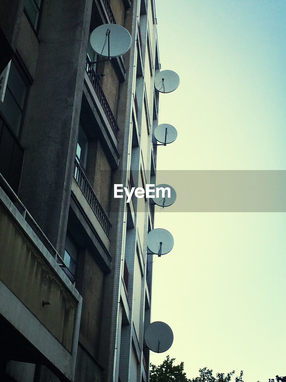 Low angle view of building with satellite dish against clear sky