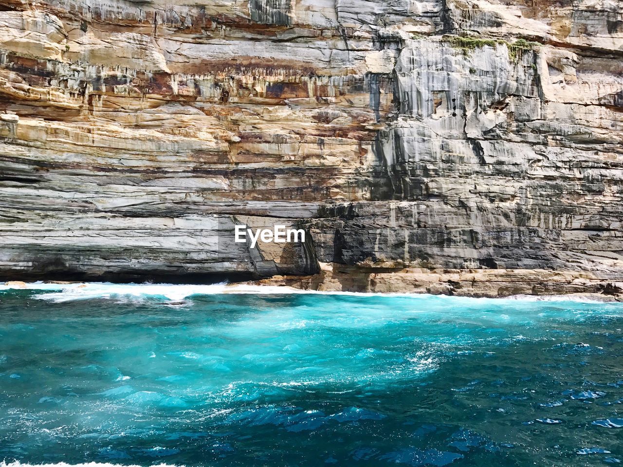 Scenic view of sea against cliff face 