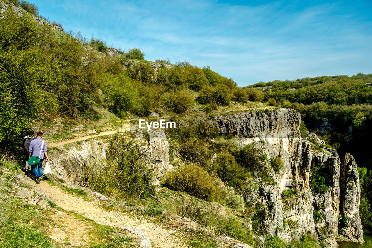 Scenic view of people walking through mountain path