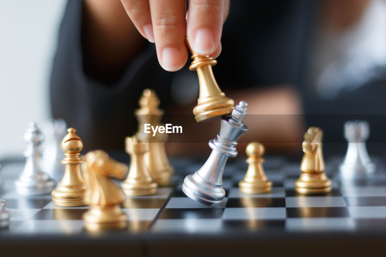 Close-up of businesswoman playing with chess at desk