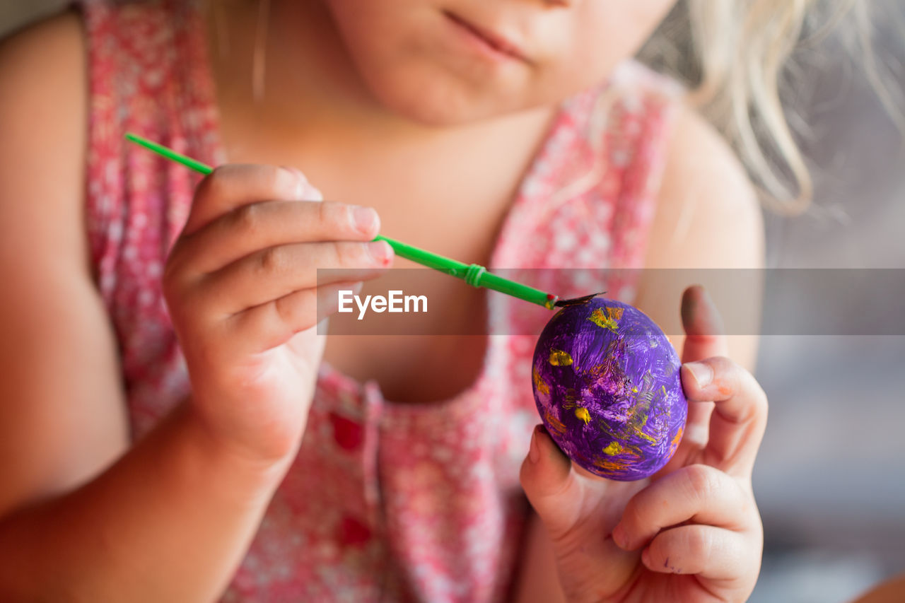 Close-up of hand painting easter egg