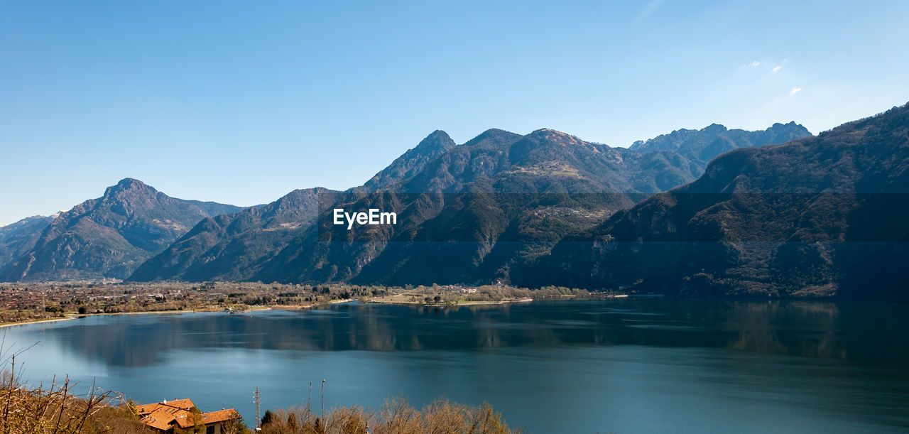 LAKE BY MOUNTAINS AGAINST CLEAR SKY