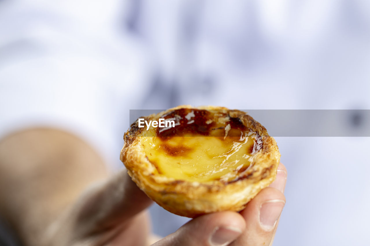 CLOSE-UP OF PERSON HAND HOLDING BREAD