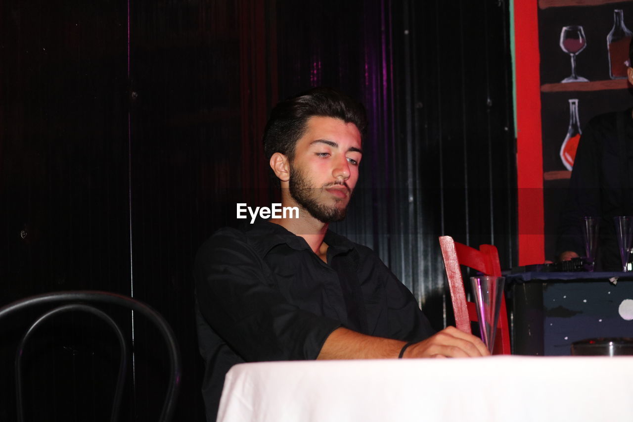 Young man sitting at table in restaurant