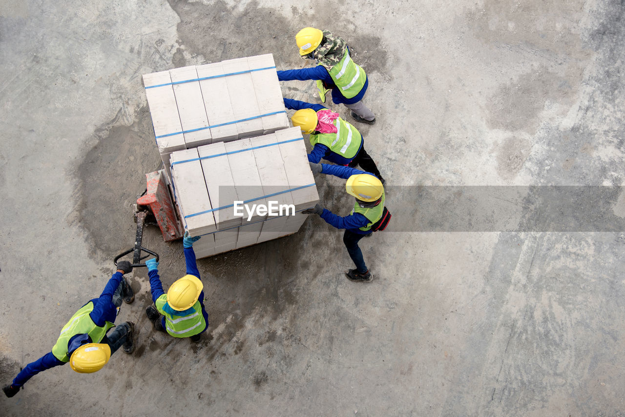 HIGH ANGLE VIEW OF MAN WORKING IN CONTAINER