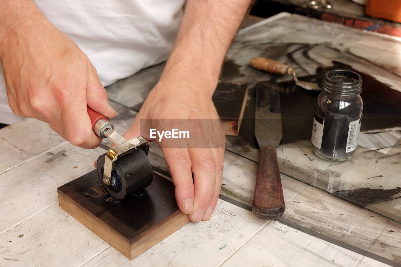 Cropped image of craftsman using printing roller in factory