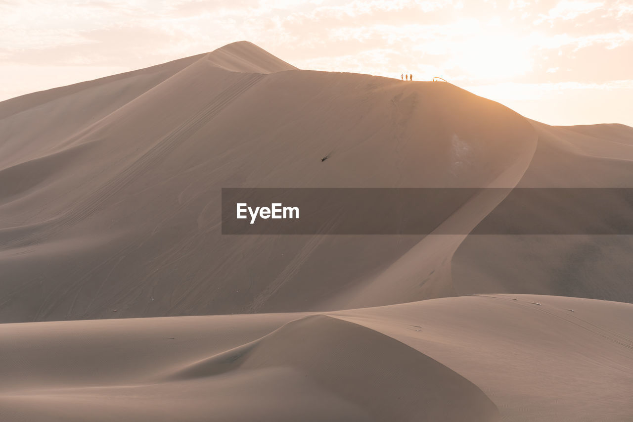 Sand dunes in desert against sky