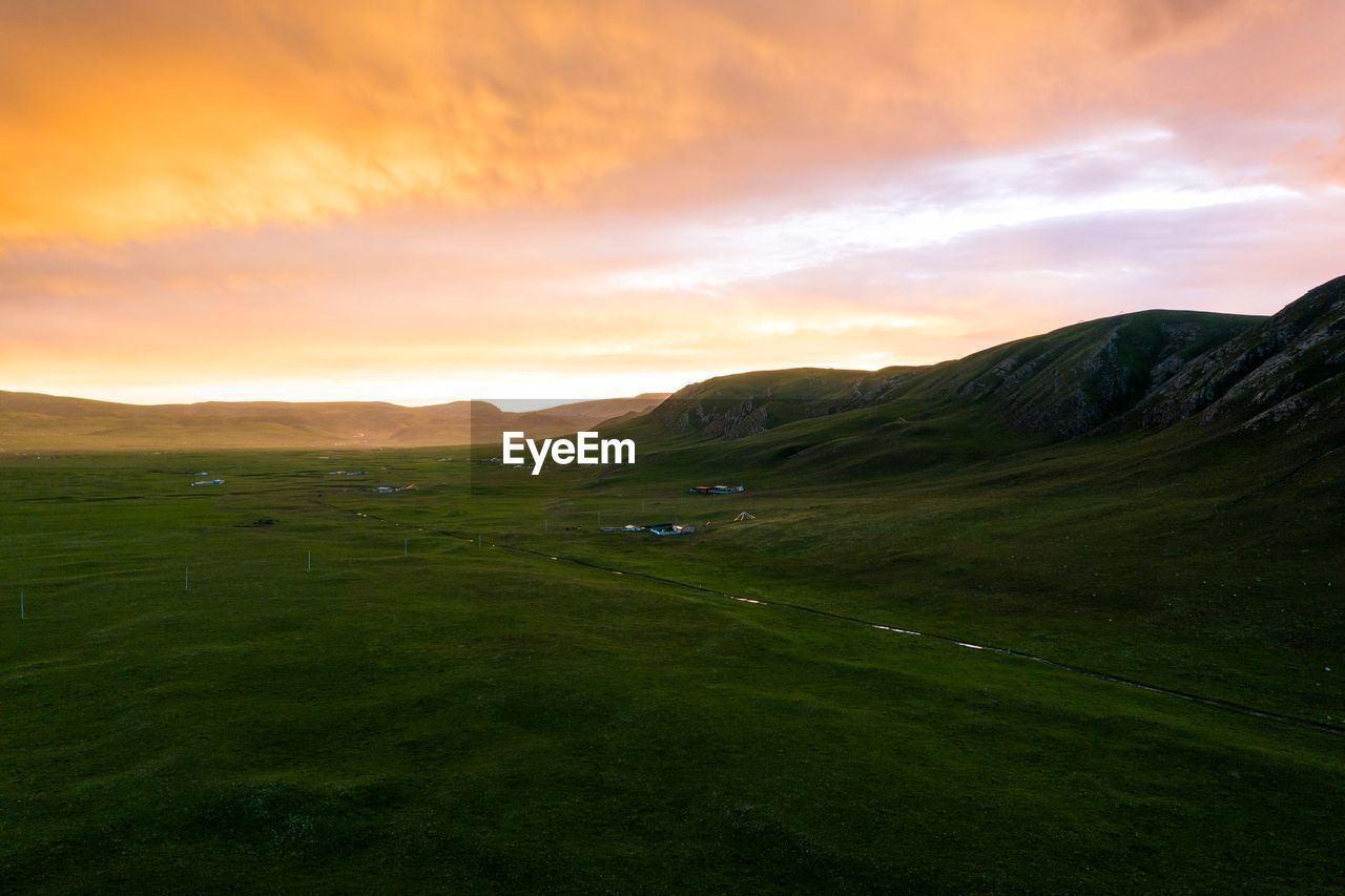 SCENIC VIEW OF FIELD AGAINST SKY AT SUNSET