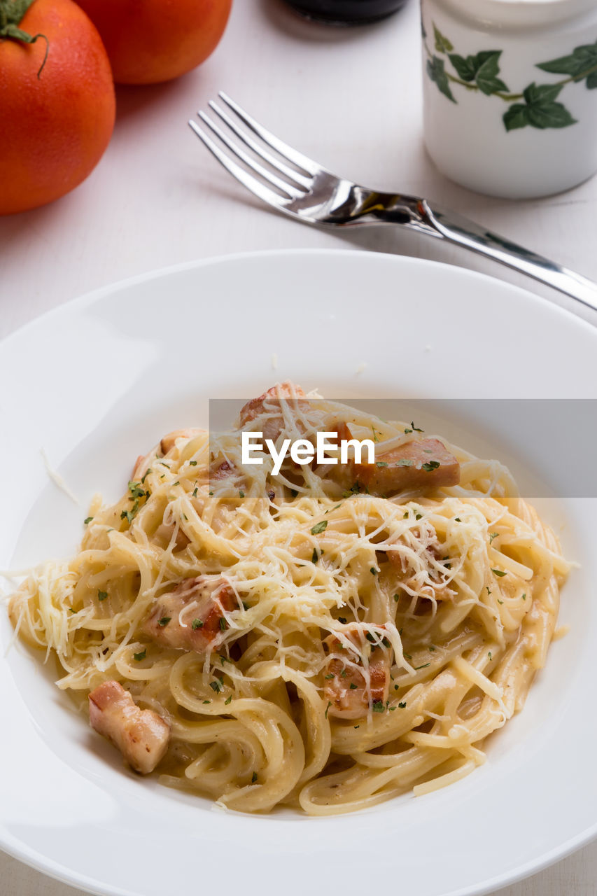High angle view of spaghetti with carbonara in plate on table