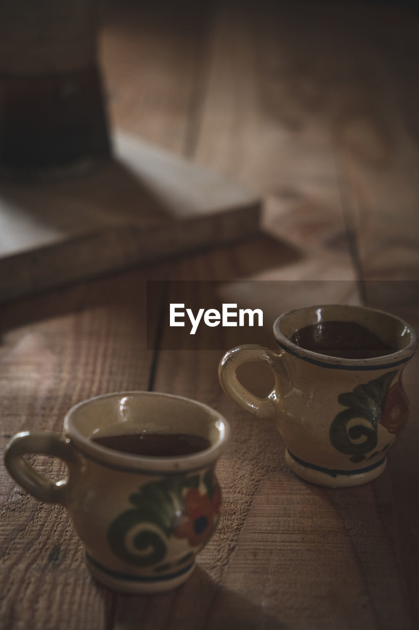 CLOSE-UP OF COFFEE CUP WITH TEA ON TABLE