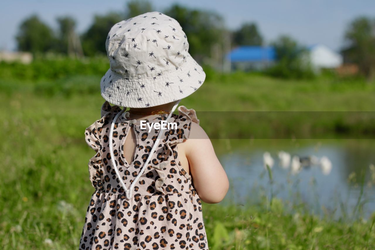 Rear view of girl standing on field