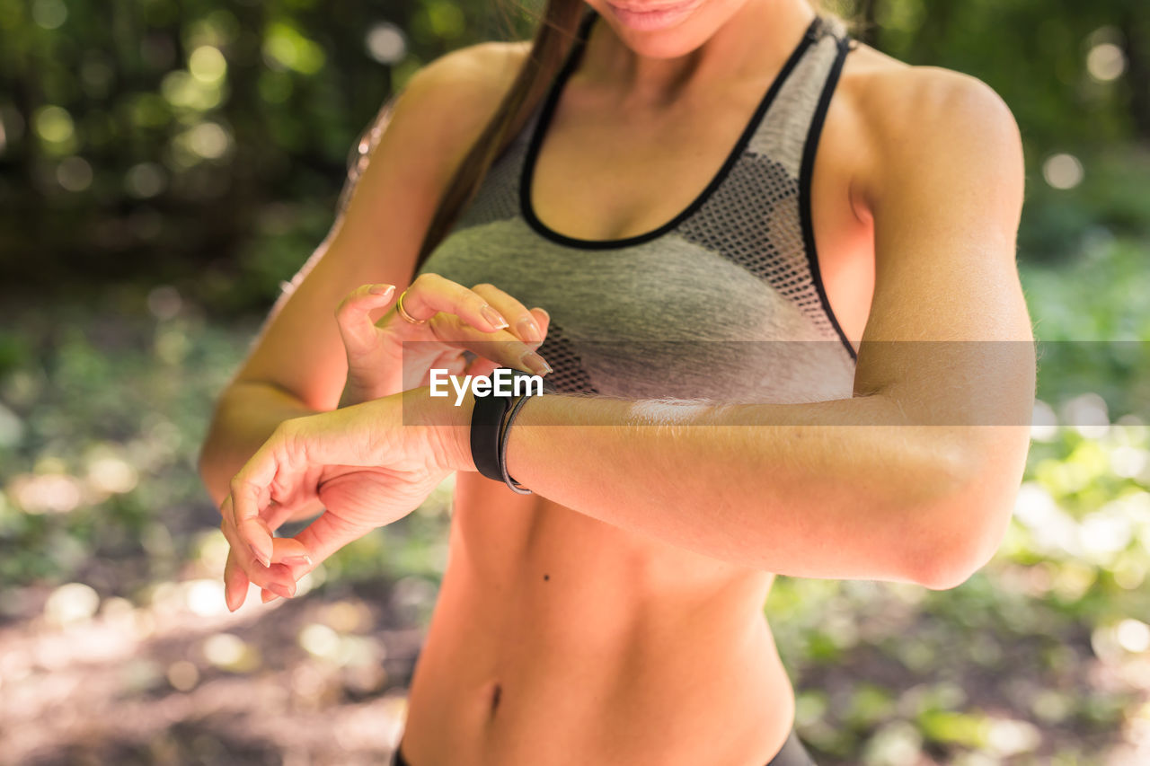 MIDSECTION OF WOMAN STANDING AGAINST BLURRED MOTION