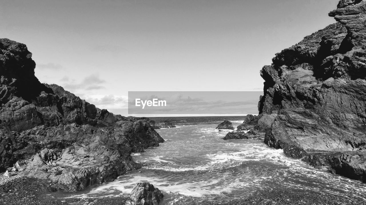 Rock formation on beach against sky