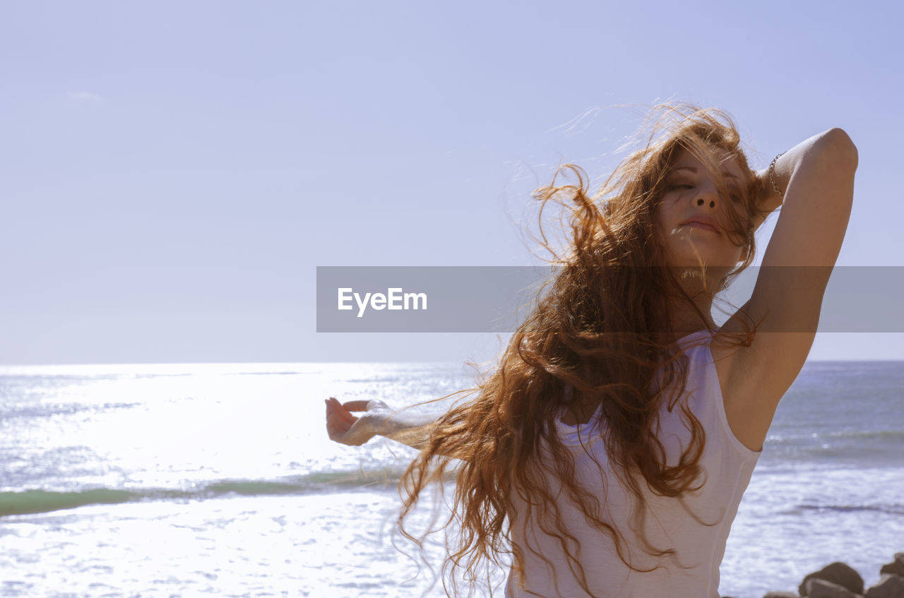 Red haired woman on windy beach