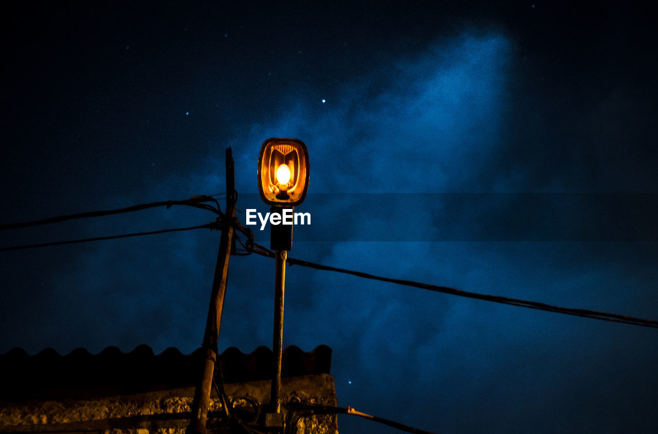 Low angle view of street light pole at night