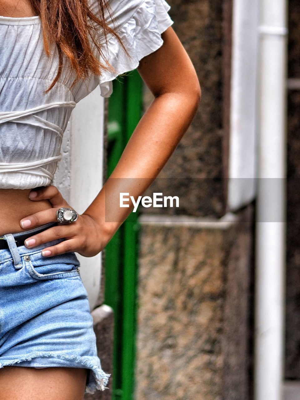 Midsection of woman standing against wall