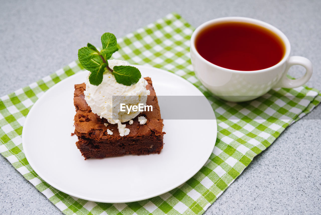 High angle view of cake on table close-up of dessert in plate brownie and ball of vanilla ice-cream