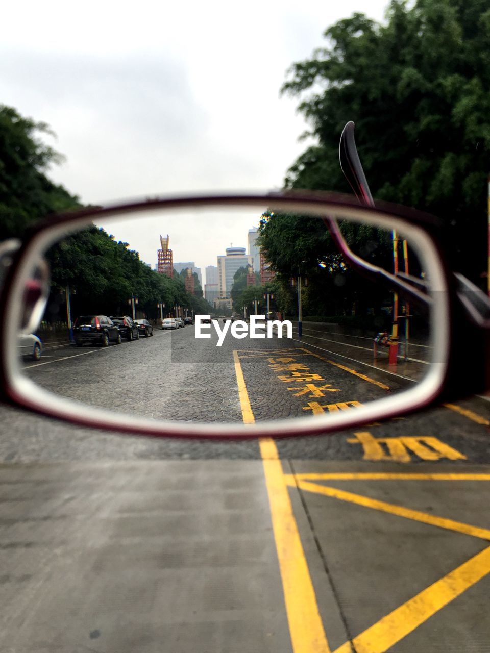 Street leading towards city seen through eyeglasses