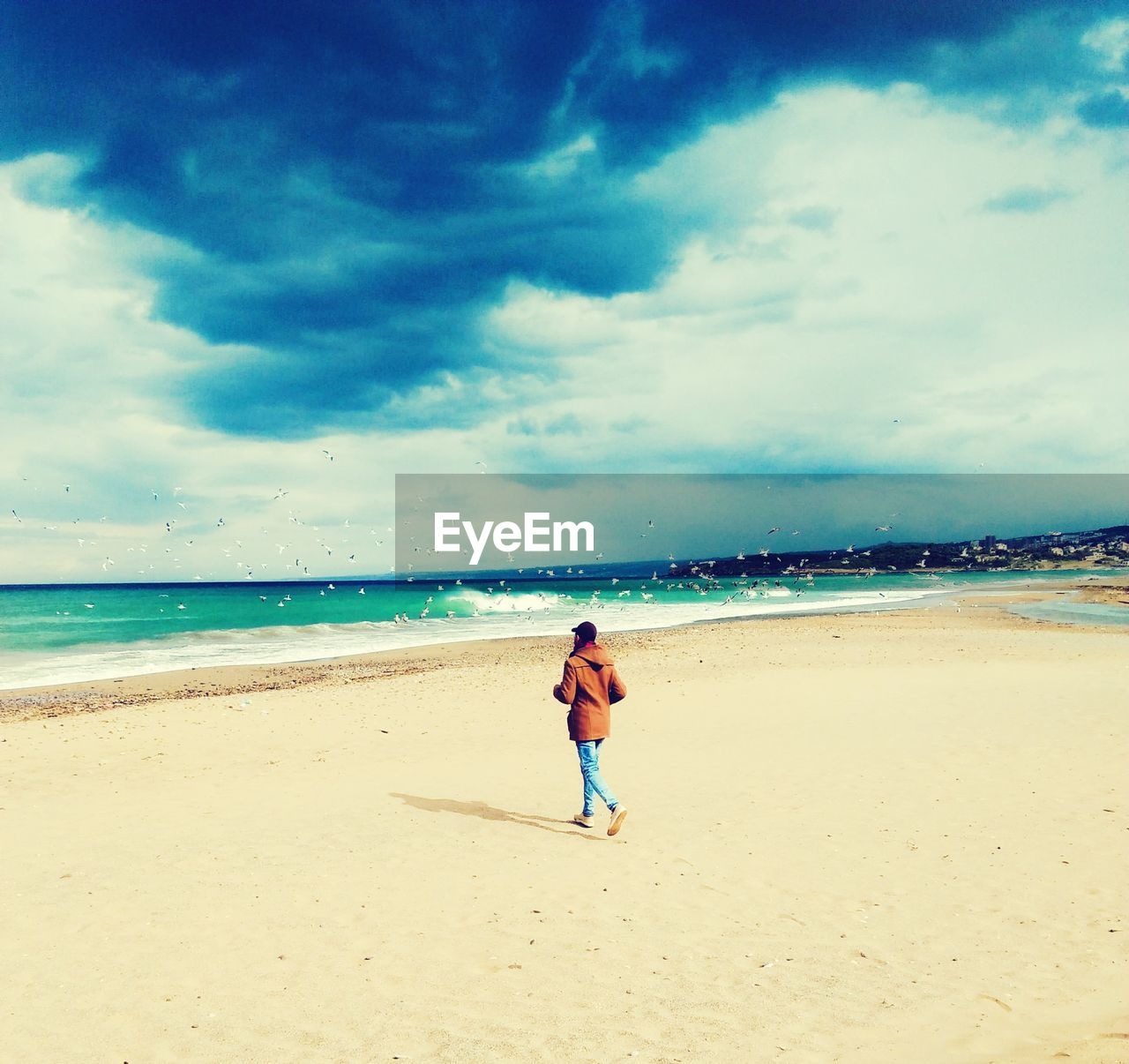 WOMAN ON BEACH AGAINST SKY