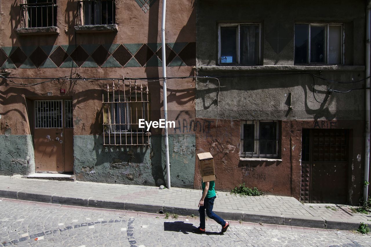 Full length of man walking against building in city