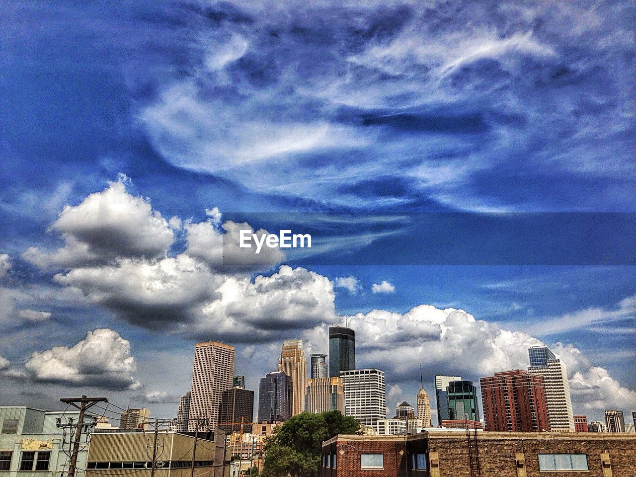 VIEW OF CITYSCAPE AGAINST CLOUDY SKY