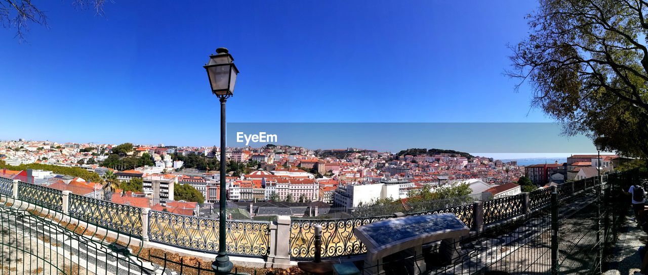 Panoramic view across rooftops of lisbon with streetlight and tree