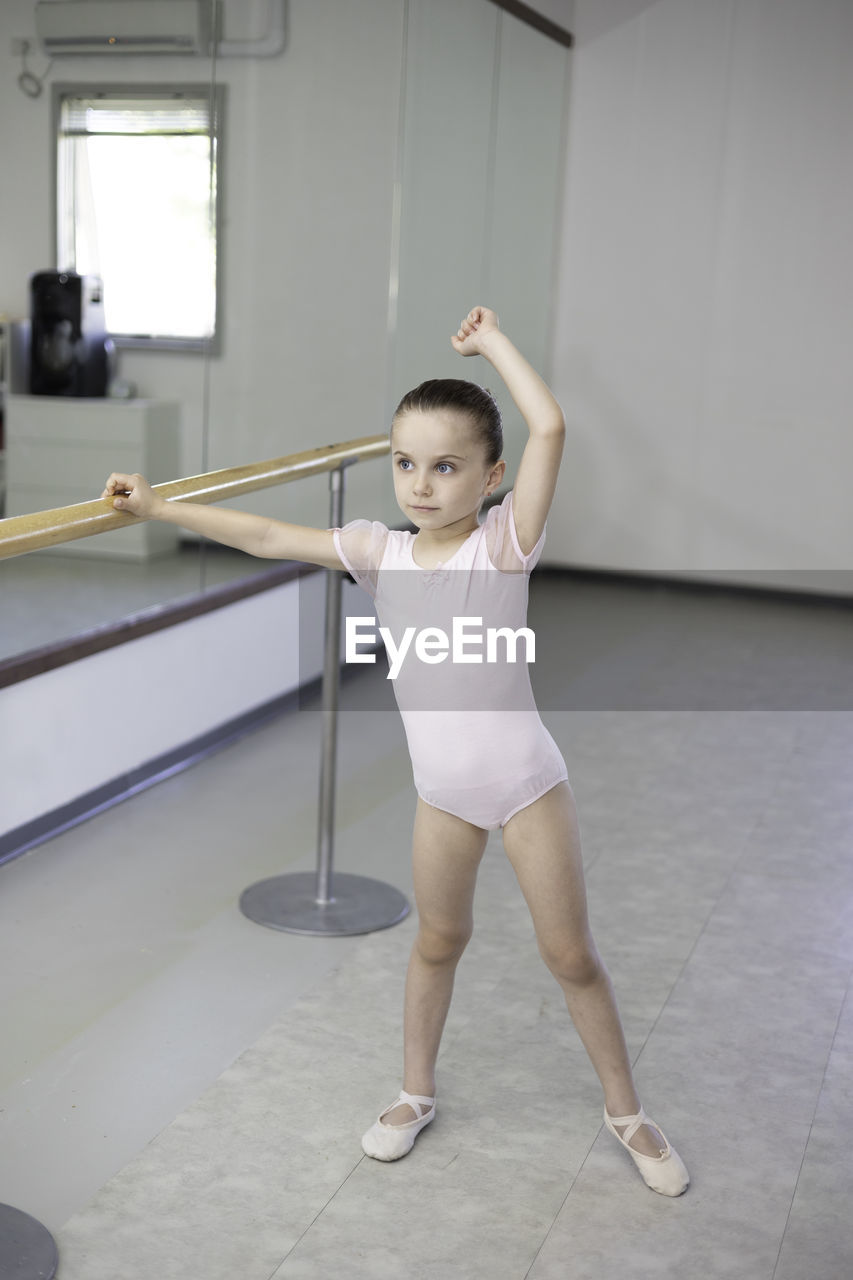 full length of young woman exercising on floor