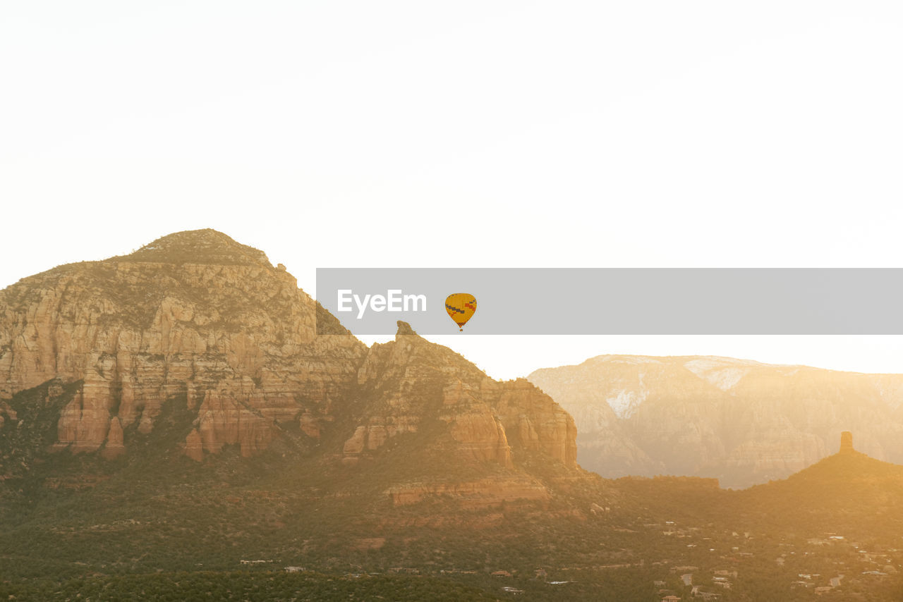 Sedona arizona hot air balloon rises at sunrise for a group of tourists on vacation.