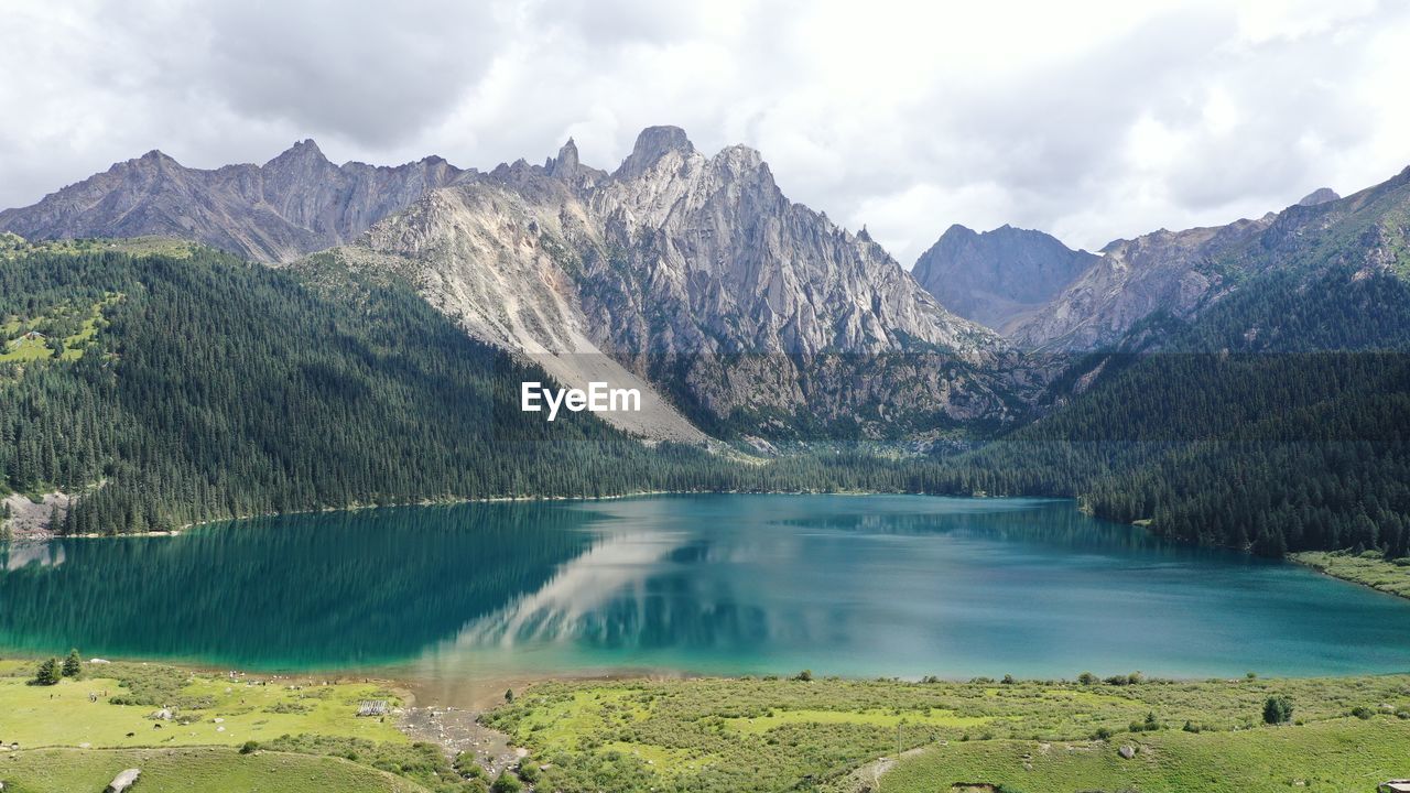 Scenic view of lake by mountains against sky