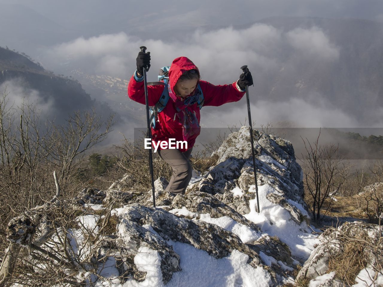 Full length of woman climbing on rock against landscape