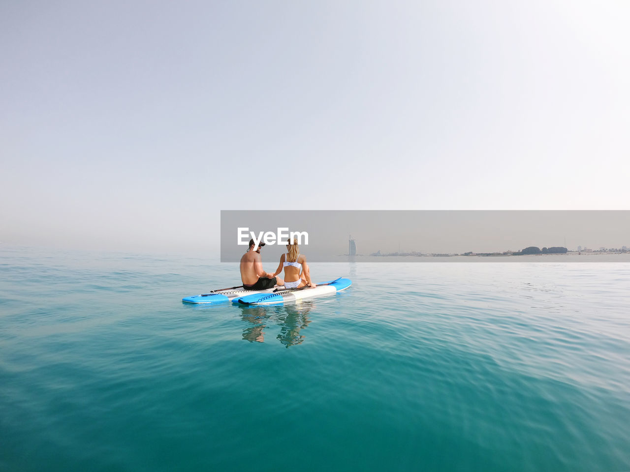 Active couple on the paddle boards with a view on burj al arab