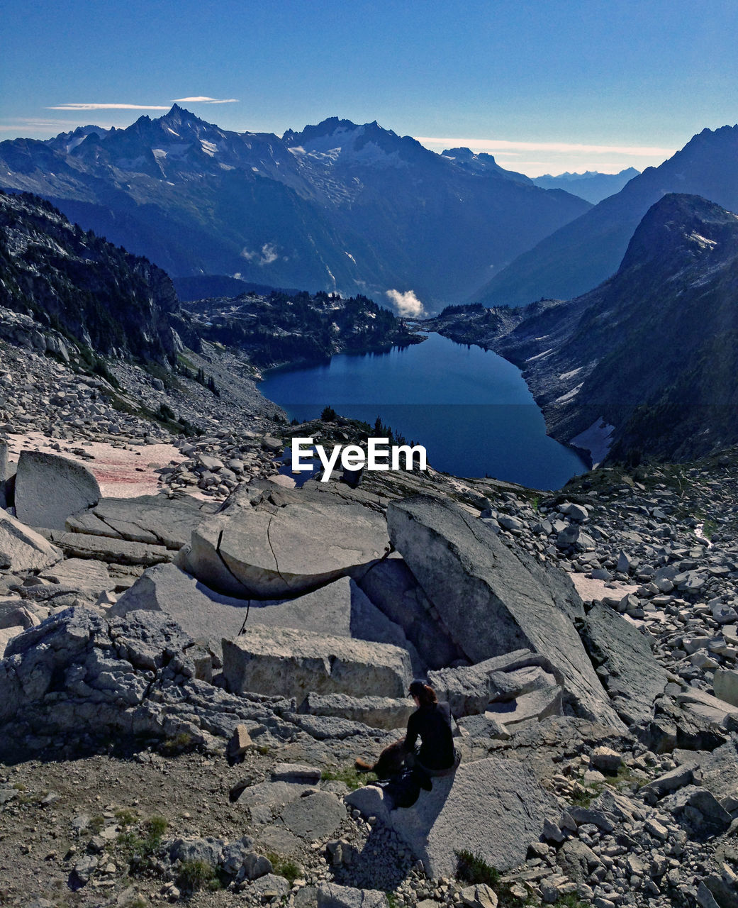 Person looking at mountains and lake against sky