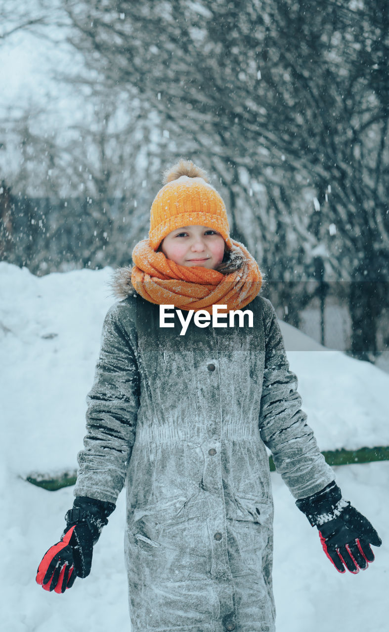 Portrait of girl standing on snow covered land