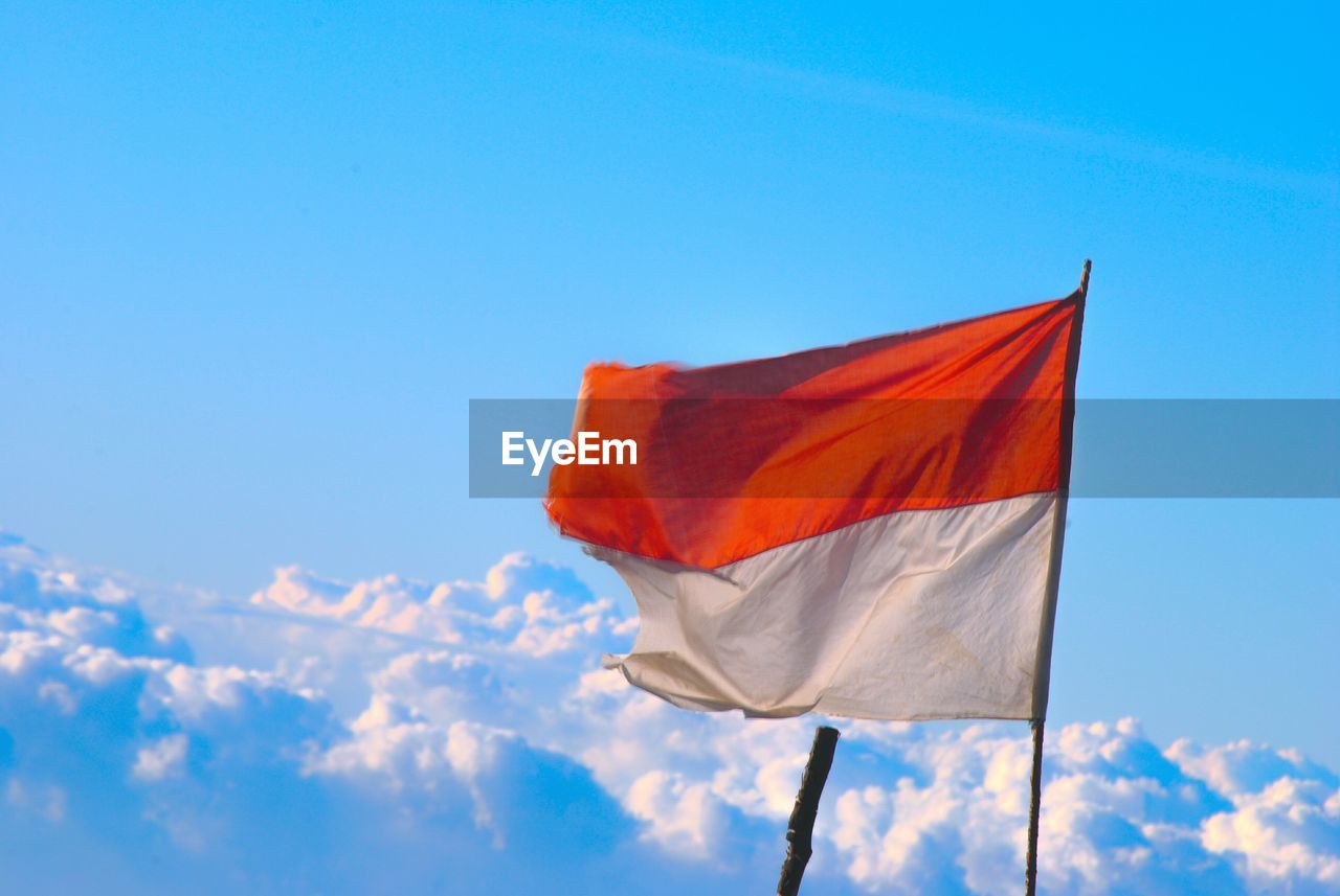 Low angle view of flag against blue sky