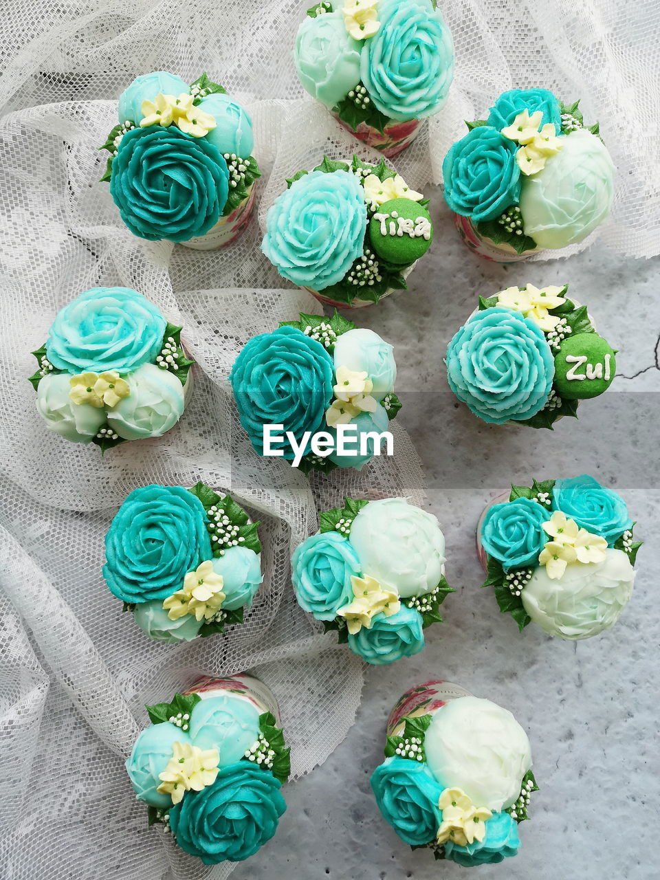 HIGH ANGLE VIEW OF MULTI COLORED CUPCAKES ON TABLE