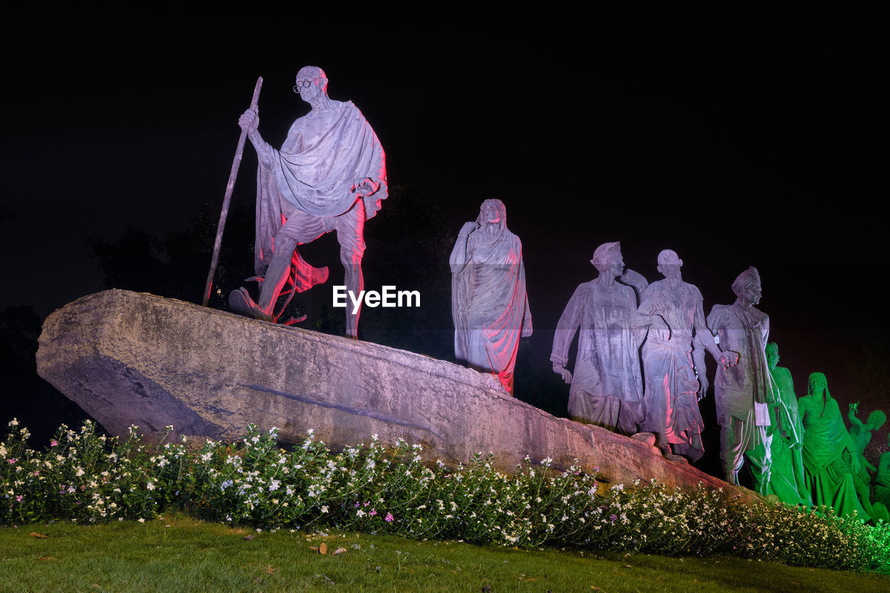 LOW ANGLE VIEW OF STATUE ON ROCK AGAINST SKY AT NIGHT