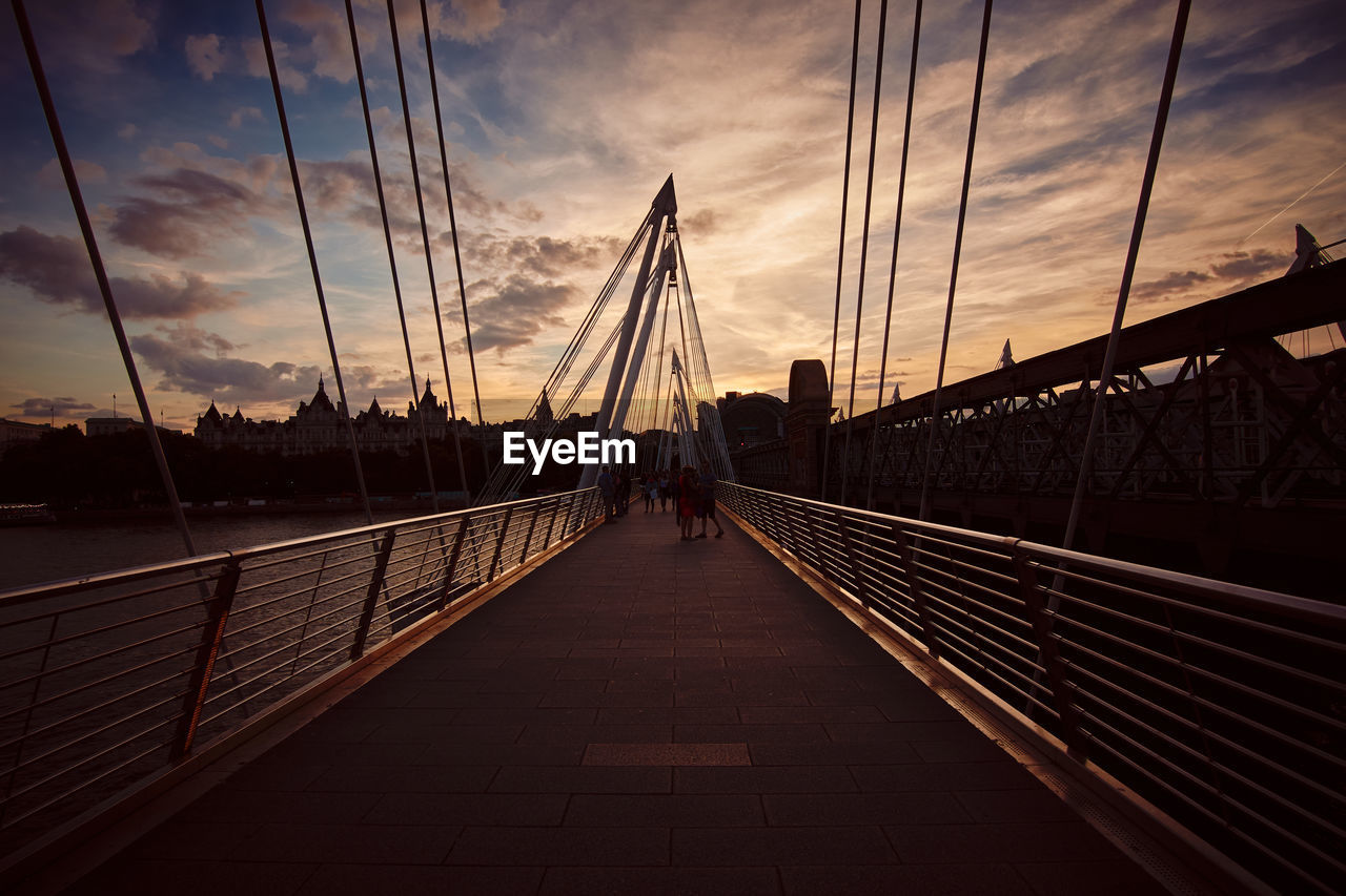 Suspension bridge against sky during sunset