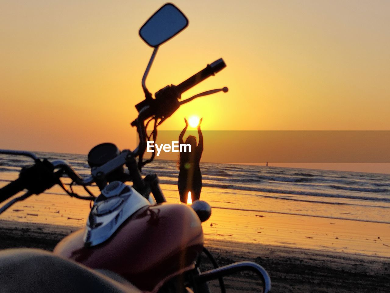 MAN RIDING MOTORCYCLE ON BEACH AGAINST SKY