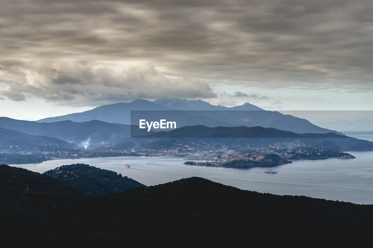 Scenic view of sea and mountains against sky